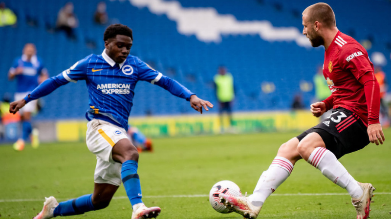 Luke Shaw of Manchester United in action with Tariq Lamptey of Brighton and Hove Albion during the Premier League match between Brighton & Hove Albion and Manchester United at American Express Community Stadium on September 26, 2020 in Brighton, England.